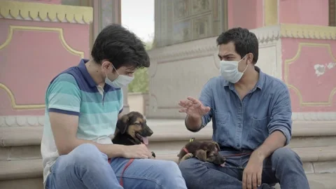 Two men talking outdoors while bringing their dogs for a walk Stock Footage 136371888