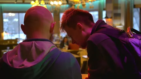 Two men talking in a restaurant. One is bald with a beard, the other has a Stock Footage 146712552