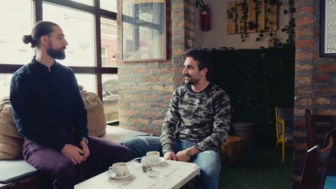 Two men talking while drinking coffee in cafeteria Stock Footage 95901720