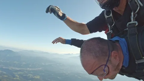 Two men tandem skydiving from airplane for sport and recreation over the Stock Footage 120155925