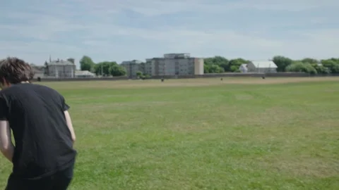 Two men throwing frisbee to each other outdoor in the sun, slow motion Stock Footage 244726972