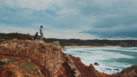 Two men on top of the coastal cliffs shot by drone Video stock 203596344