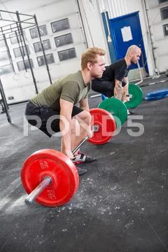 Two men train deadlift at crossfit center Stock-Fotos