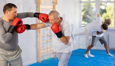 Two men training boxing fight in studio Stock Photos
