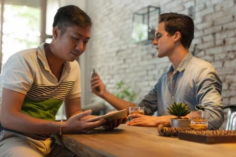 Two Men Using Internet Technology Tablet Computer and Smart Phone Stock Photos