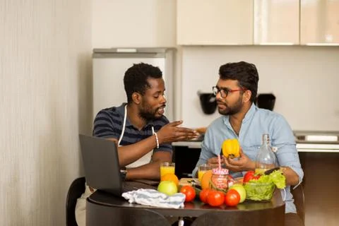 Two men using laptop in kitchen Stock Photos