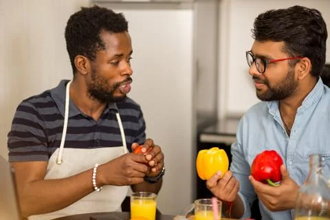 Two men using laptop in kitchen Stock Photos