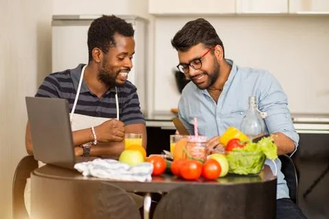 Two men using laptop in kitchen Stock Photos