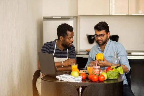 Two men using laptop in kitchen Stock Photos