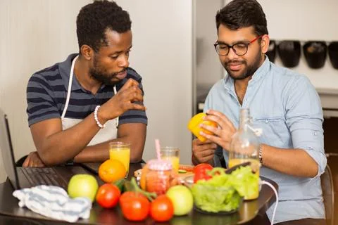 Two men using laptop in kitchen Stock Photos