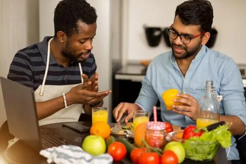 Two men using laptop in kitchen Stock Photos