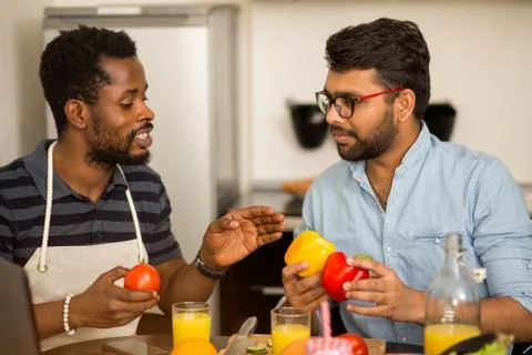 Two men using laptop in kitchen Stock Photos