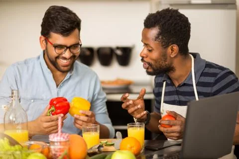 Two men using laptop in kitchen Stock Photos