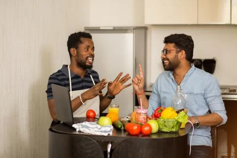Two men using laptop in kitchen Stock Photos