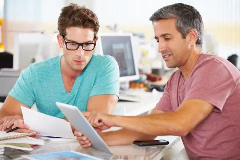 Two men using tablet computer in creative office Foto stock