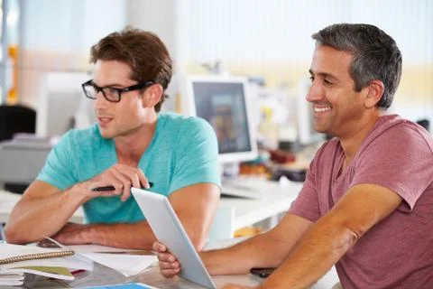 Two men using tablet computer in creative office Foto stock