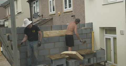 Two men using trowels on a building site close-up Stock Footage 246380961