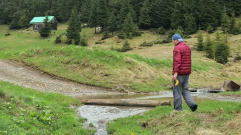 Two Men Wading Across a Stream in the Ukrainian Carpathians During Early Spri Stock Footage 286701198