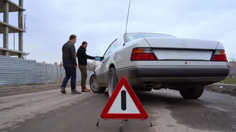 Two men walk around car at scene of accident. Emergency sign, insurance damage. Stock Footage 271608955