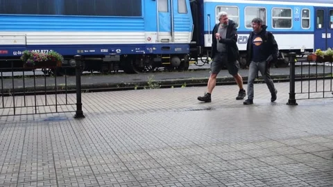 Two men walk in the station and the train departing Stock Footage 157233492