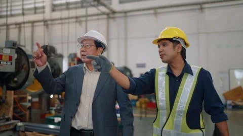 Two men walk through a factory floor Stock Footage 341651658