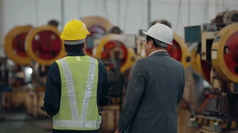 Two men walk through a factory floor Stock Footage 341651792