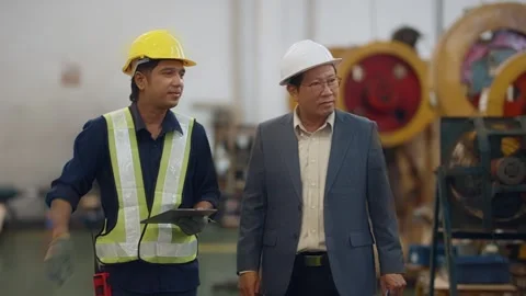 Two men walk through a factory floor Stock Footage 341654876