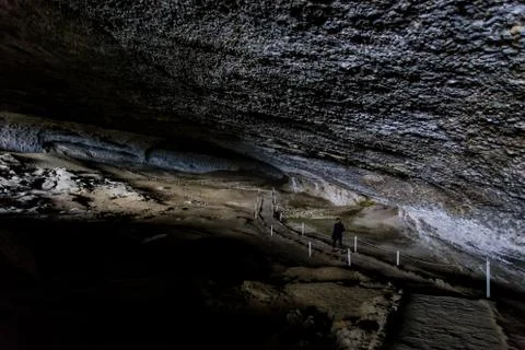 Two men walking along pathway in the Milondon Cave, Puerto Natales, Patagonia Stock-Fotos