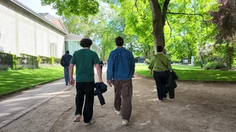 Two Men Walking Along a Shaded Pathway in Tuileries Garden Paris Stock Footage 335850558