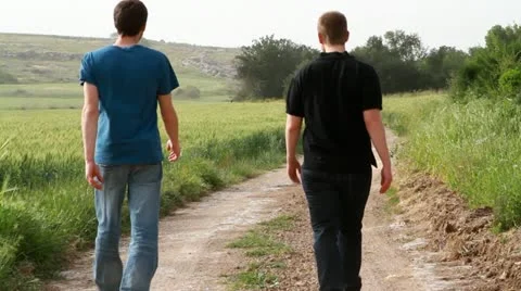 Two men walking and talking in field 스톡 동영상 22340392