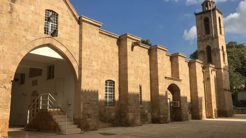Two men walking in front of an Old Church in Nicosia Stock-Footage 99841502