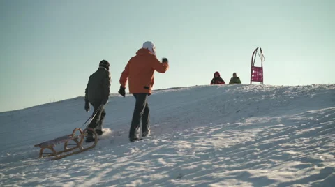 Two men walking up hill with sled Stock Footage 59594678
