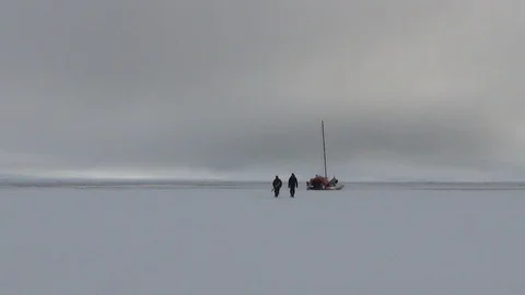Two men walking on the ice floe near a catamaran, Arctic Ocean Stock Footage 104871977