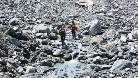 Two men walking through the eroded mountains Stock Footage 77450356