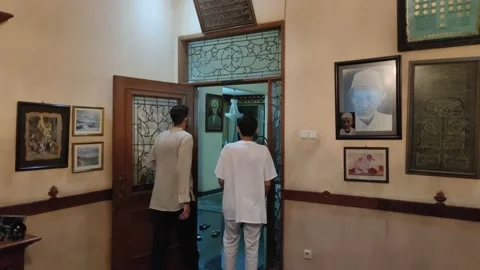 Two men walking through inside a house 스톡 동영상 162619170