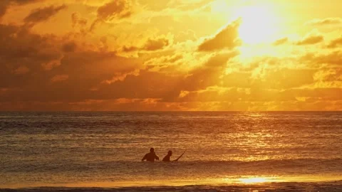 Two men in a water looking the sunset Stock Footage 300424722