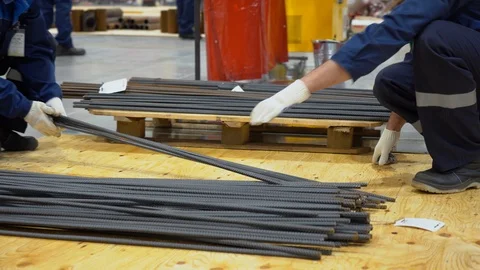 Two men wear protective gloves moving bars of cut rebar at stack close up Stock Footage 126355771