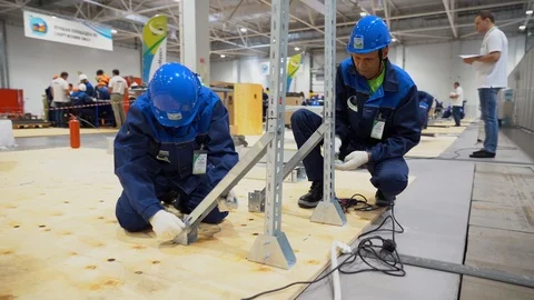 Two men wear uniforms, helmets, gloves doing fixing work at construction site. Stock Footage 126356343