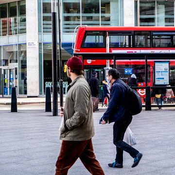 Two Men Wearing Protective Face Masks With A Red London Bus in The Background Stock Photos