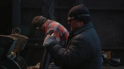 Two men wearing protective glasses and gloves working in metallurgical industry. Stock Footage 296542651