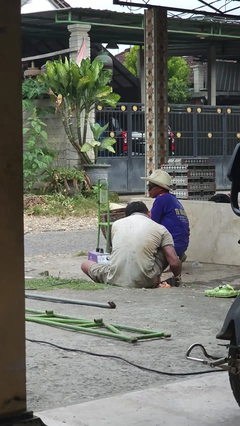 Two Men Welding Metal Pieces While Sitting On The Ground Outdoors Stock Footage 340079003