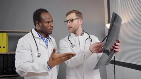 Two Men in White Lab Coats Analyzing X-ray image Stock Footage 264981355
