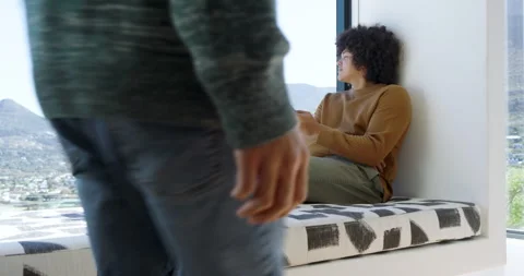 Two men at window bench one scrolling smartphone then other entering and hugging Stock Footage 311026236
