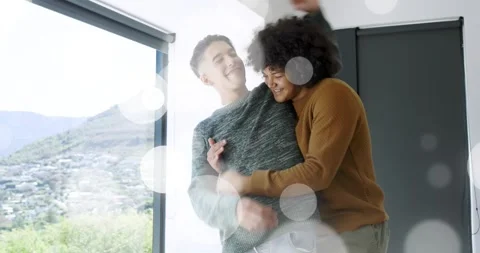 Two men by window, man entering placing hands leading pair embracing, home bokeh Vídeo Stock 323355068