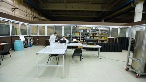 Two men work on a computer in the Technopark premises. Workers in white coats Stock Footage 95346633