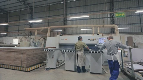 Two men work in a factory. Workflow in a furniture factory. Two Asian men work Видео 116402663