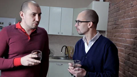 Two men at work in the office at lunchtime drink coffee and discuss work Stock Footage 101264860