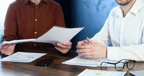 Two men work with securities on the desktop, close-up. Video stock 241801344