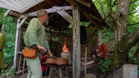 Two men work under a rustic wooden shelter Fotos Stock