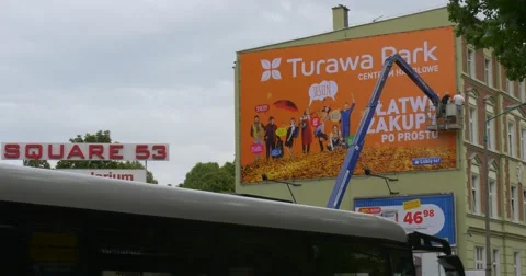 Two Men Workers in a Truck Tower Are Installing an Orange Advertisement Banner Stock Footage 54839408